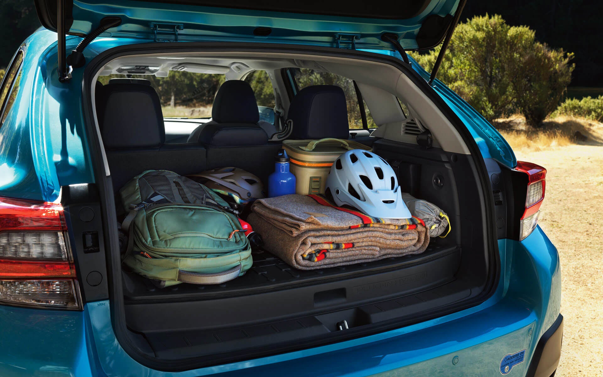 A backpack, blanket, and bike helmet in the rear cargo area of a Crosstrek Hybrid | Island Subaru in Staten Island NY