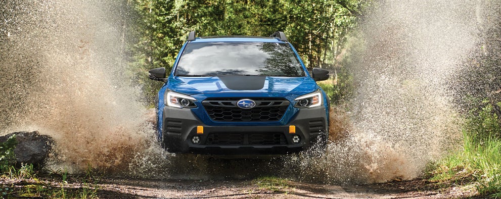 A 2023 Outback Wilderness driving on a muddy trail. | Island Subaru in Staten Island NY